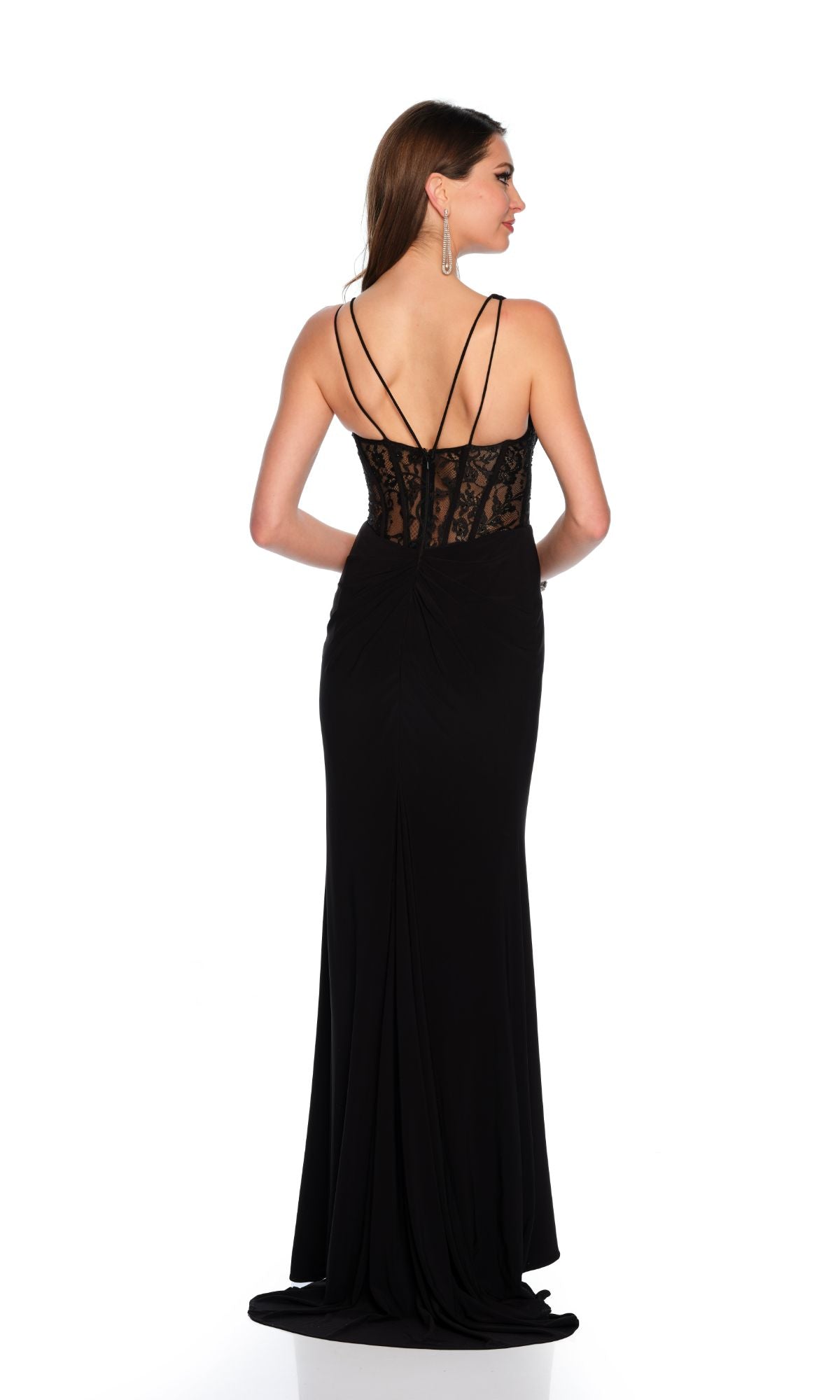 Woman wearing the Long Formal Dress 11450 by Dave and Johnny, featuring a black fitted silhouette with a sheer lace bodice and thin straps, stands facing away from the camera against a white background.